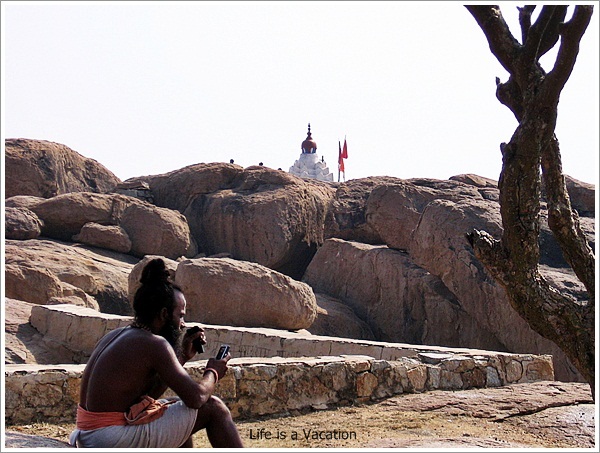The Priest and his Mobile in Hampi Anjani Parvat,India